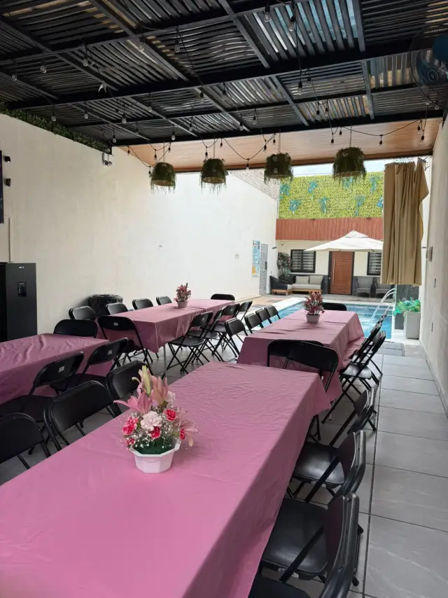 Área techada montada con mesas, manteles y sillas para un cumpleaños en Terraza Plutarco
